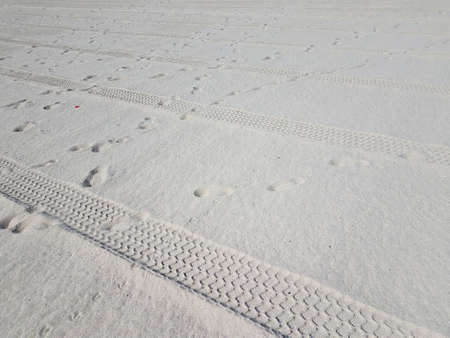 tire tracks and foot prints on combed beach