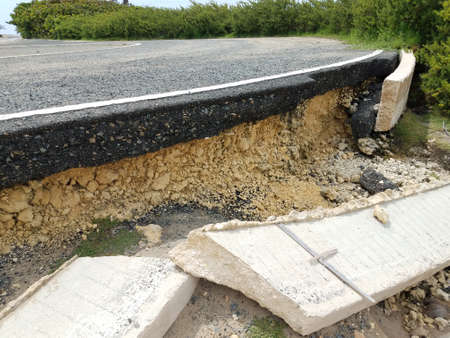 broken cement road on beach in Isabela Puerto Rico with buildingsの写真素材