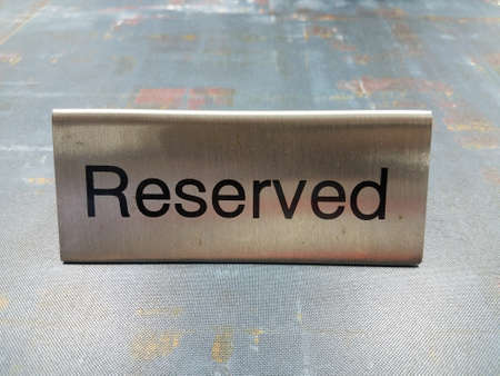 metal reserved sign for reservation on green tableの写真素材