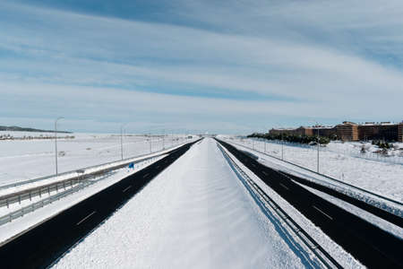 snowy highway recently cleared by snowplows on a clear dayの写真素材