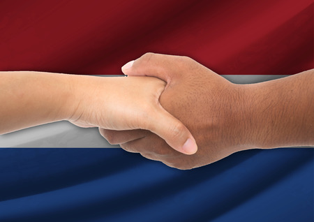 Businessmen shaking hands with flag on background - Netherlandsの写真素材