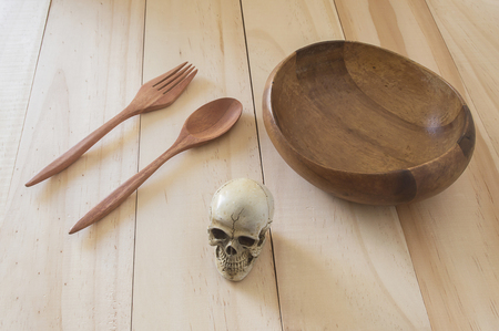 Close up skull with wood bowl and spoon,fork on wood background,Still lifeの写真素材