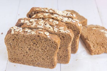 Fresh whole grain bread on white wood background