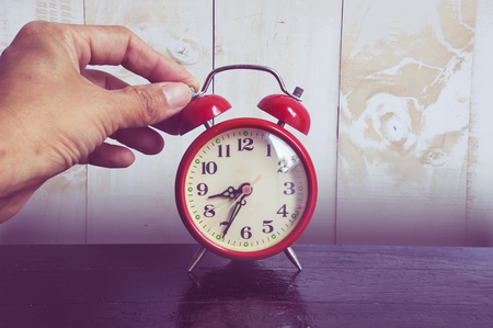 Red clock on wood background.