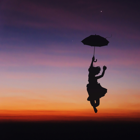 Umbrella little girl jumping and sunset silhouette.の写真素材