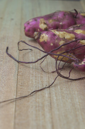 Purple Sweet Potatoes on a wooden table,Healthy food.の写真素材