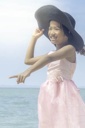 Happy little girl playing on the beach.の写真素材