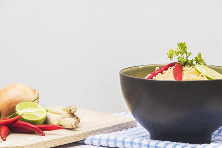 Instant noodles in bowl on wood background