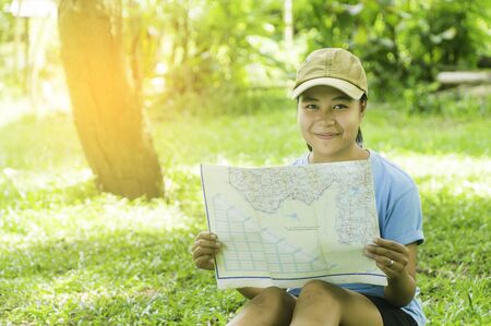 Traveler woman with map and backpack enjoying sunset on forest peak mountain,looking on view,...