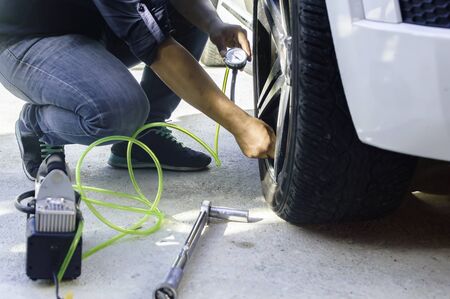 Auto mechanic uses a Car Tire Pressure Check in the Auto Service Garage.,Selective focus.の写真素材