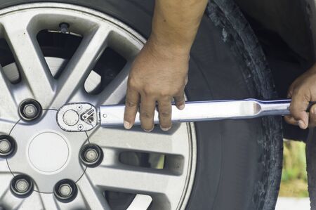 Auto mechanic uses a Car changing tire in professional car repair service in the Auto Service...