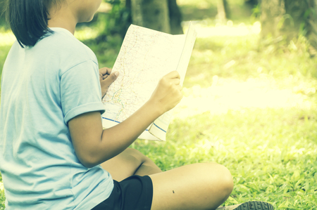 Traveler woman with map and backpack enjoying sunset on forest peak mountain,looking on view, Outdoors tourism.の写真素材