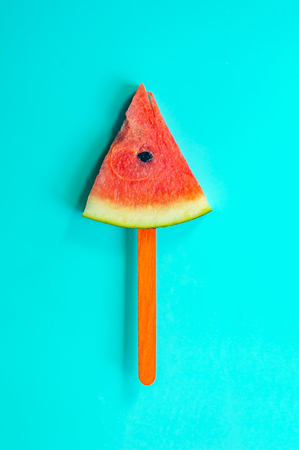 Summer watermelon slice popsicles on a blue rustic wood background. copy space for designer
