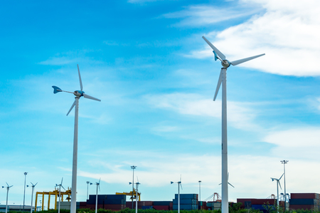 Wind turbine or windmill generating electricity on blue sky background