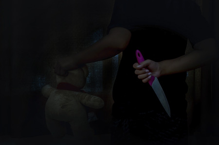 Closeup Vampire little boy holding knife hidden for kill  in house of ruin, nightmare, horror of...