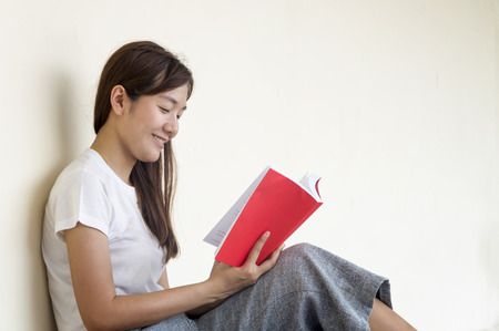 Beautiful woman of a student sitting with laptop and relaxing in the garden. Education concept.の写真素材