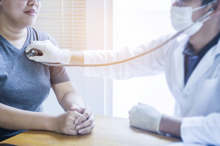 Doctor checking her pulse. Male physician examining female patient in hospital room. gynecological...