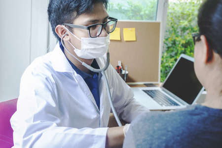 Doctor checking her pulse. Male physician examining female patient in hospital room. gynecological health in medical clinic or hospital healthcare service centerの写真素材