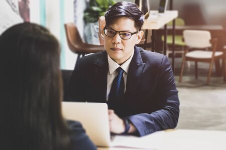 Portrait of  businessman holding resume and talking to female candidate during corporate meeting or job interview - business, career and placement conceptの写真素材