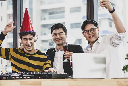 Group of happy young people drinking champagne and dancing happily at the office.の写真素材