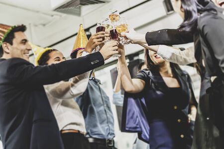 Business people of successful with drinking champagne, talking and smiling while celebrating in officeの写真素材
