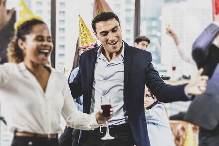 Business people of successful with drinking champagne, talking and smiling while celebrating in officeの写真素材