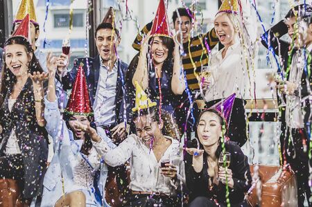 Business people of successful with drinking champagne, talking and smiling while celebrating in officeの写真素材