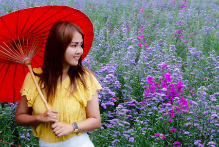 Travel asian adult woman relax in nature sitting in margaret flower field. In yellow shirt style....