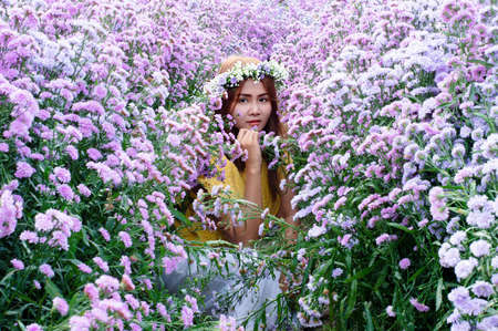 Travel asian adult woman relax in nature sitting in margaret flower field. In yellow shirt style....