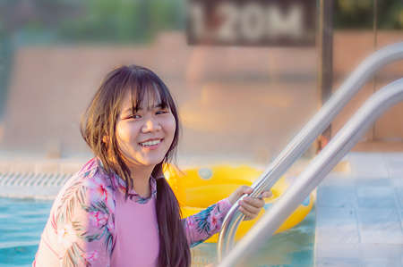 Young asian woman relaxing at spa pool. Beautiful woman relaxing in outdoor spa swimming pool with...