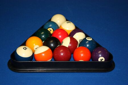 Poolballs or billard balls racked up in a rack on the pool table closeup.