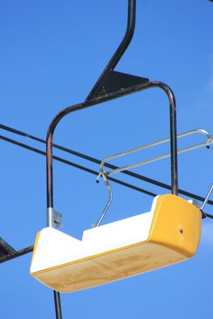 A yellow ride  seat at a fair with bluesky and clouds
