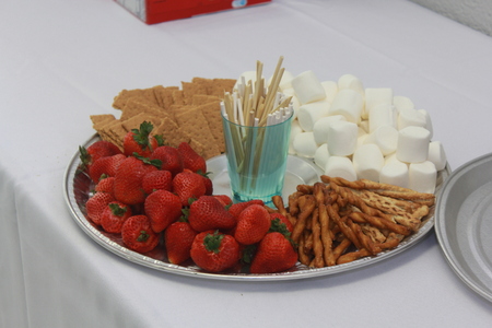 Red Strawberrys on a plate with Marshmallows, pretzels, and Graham Crackers that's bright and colorful on a table with a white table cloth.の写真素材