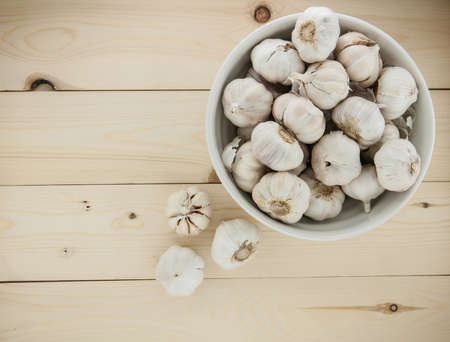 Organic garlic whole and cloves on the wooden backgroundの写真素材