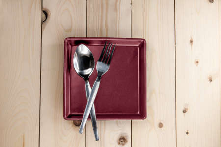 Plate and cutlery on wooden table