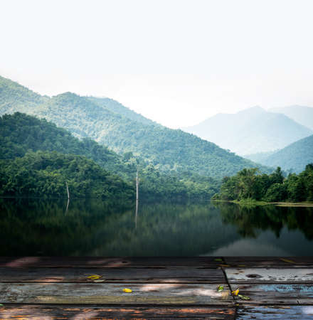vintage wooden board table in front of dreamy and abstract forest landscape lagoonの写真素材