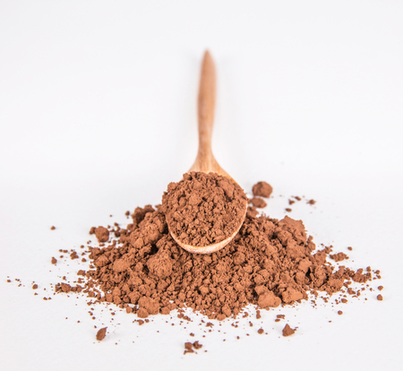 cocoa powder and wooden spoon on whiteの写真素材