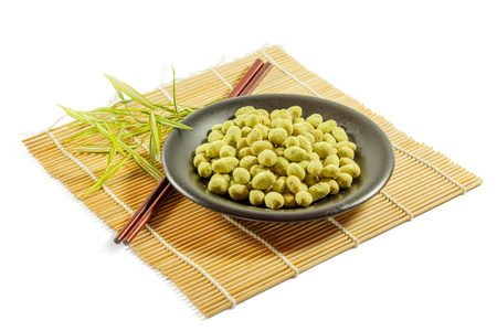 coated peanuts wasabi flavour in brown plate with a white backgroundの写真素材