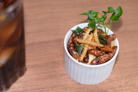 Insects - Wood worm, Silkworms fried insect, Tasty potatoes fries and chopsticks on white plate with...