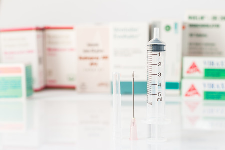 Syringe - Typical plastic medical syringe, fitted with a detachable stainless steel needle, Single use only. Shot in the studioの写真素材