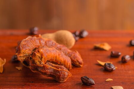 Tamarind - Sweet ripe tamarind and seeds on rustic wooden table with wooden background. Selective focus and toned image. Top view, Copy space.の写真素材