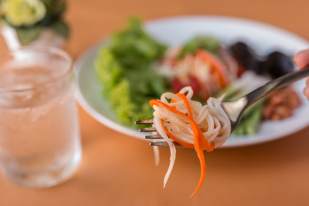 Papaya Salad - Thai green papaya salad on a fork Traditional spicy Thai food. Closeup, Select focusの写真素材