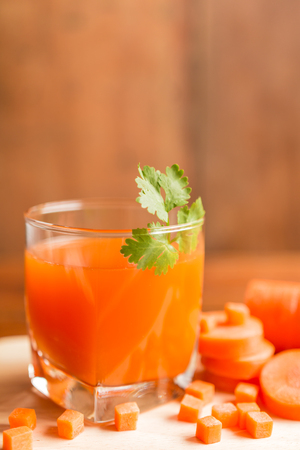 Carrots, Delicious sweet drink fresh carrot juice with coriander leaves on a rustic wooden table. Selective focus and toned image. Copy space. の写真素材