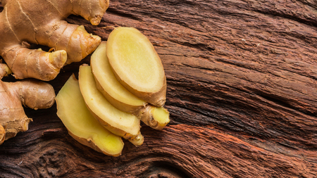 Ginger root - Fresh ginger root and sliced on old plank with nature background. Close-up, Selective...