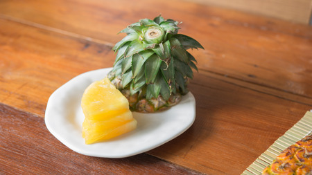 Pineapple with slices - Fresh of pineapple slices Asian-style on the bamboo place mats background. Tropical fruit concept. Selective focus.の写真素材