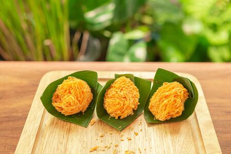 Foi Thong,  (Shredded Egg Yolk Tart) Thai desserts ingredients, used Egg yolks and sugar are boiled in sweet syrup and then formed into hairlike shapes on a banana leaf. Selective focusの写真素材