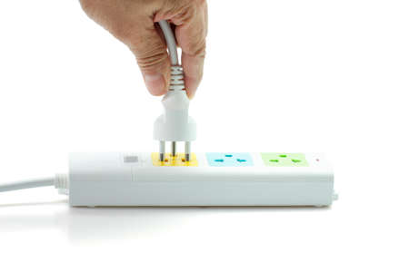 Close-up, Hand holding an electric plug ready to connect power strip on white background.