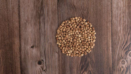 Top view macro close-up on plenty of dry cardamom spice on wooden background, horizontal format, with copy space for text.の写真素材