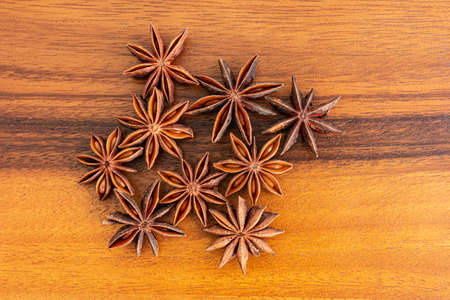 Anise stars on wooden, top view.