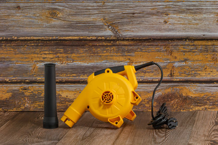 Yellow electric handheld air blower. It has a long nozzle to be a powerful tool, likely used for...